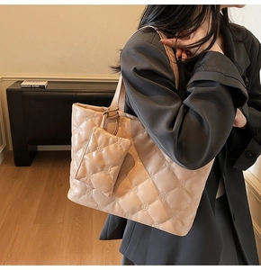 Detail of beige quilted tote bag with floral stitching and matching mini pouch