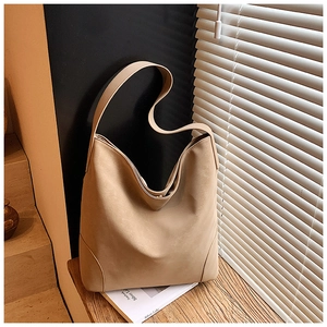 Detail of minimalist beige oversized hobo tote bag on a wooden bench with natural lighting