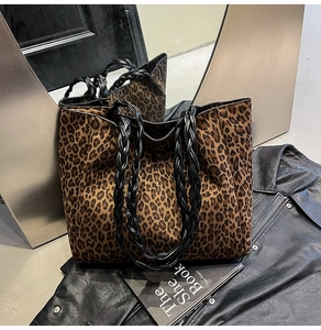 Detailed close-up of leopard print tote bag with black woven rope handle and canvas texture
