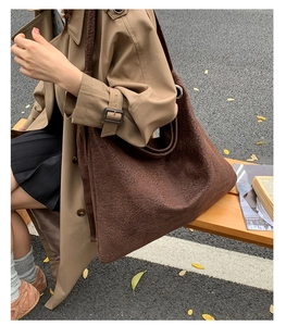 Detail of dark brown leopard print tote bag in soft suede fabric on an outdoor bench