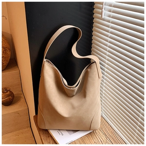 Close-up of beige leopard tote bag texture with wide shoulder strap on wooden bench