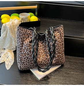 Detail of leopard print tote bag featuring black twisted rope handles and large capacity