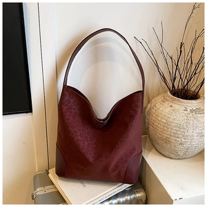 Detail of burgundy leopard print hobo bag showing textured fabric and reinforced base corners