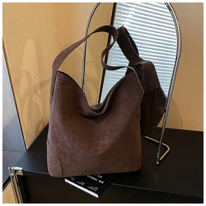 Detail of vintage brown leather hobo bag showing retro texture and wide shoulder strap