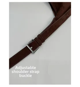 Detail of brown suede shoulder strap with adjustable silver square buckle and punch holes
