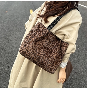 Close-up of leopard print tote bag featuring unique black woven rope handles and fabric texture