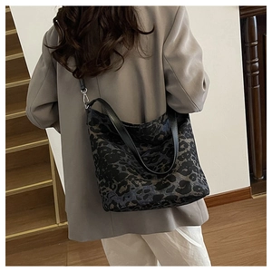 Detail of leopard print bucket bag with black adjustable strap and silver metal buckle