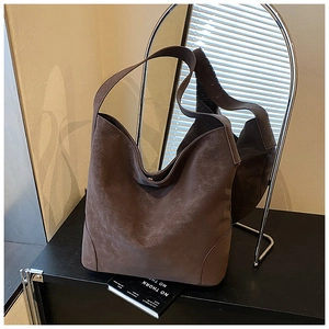 Close-up of matte dark brown hobo bag featuring wide strap and magnetic closure detail