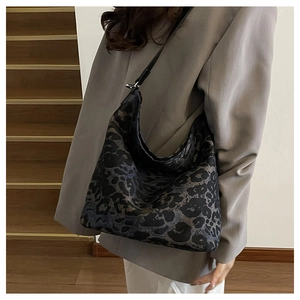 Detail of leopard print canvas tote bag with slim black leather shoulder strap and large capacity