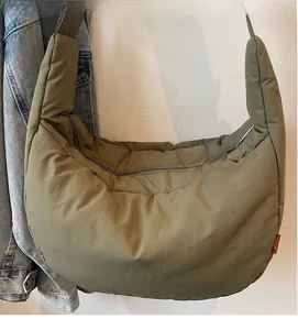 Detail of olive green quilted canvas crossbody bag with soft padded texture and zipper closure
