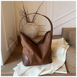 Detail shot of leopard print tote bag with brown leather corner reinforcement