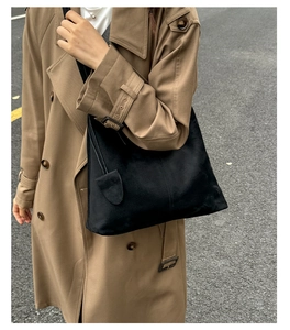 Chic black faux suede tote bag shown on a model wearing a classic trench coat