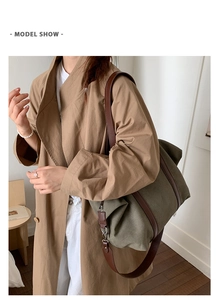 Vue détaillée du sac cabas en toile vert armée avec poignées en cuir porté par un modèle