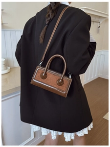 Detail of a vintage brown leather crossbody bag with patchwork design and silver hardware