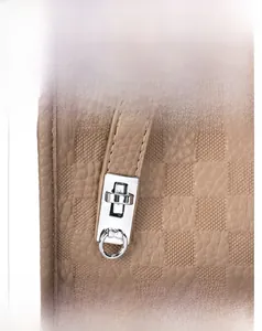 Detail view of coffee plaid embossed texture and premium silver metal twist lock closure