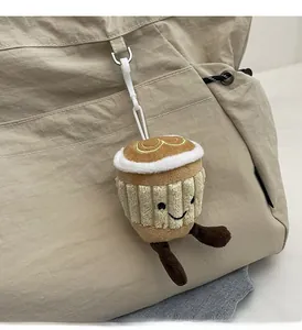 Détail d'un porte-clés en peluche tasse à café avec sourire sur un sac fourre-tout