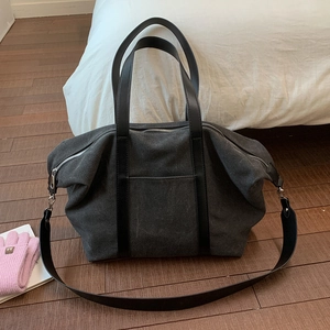 Détail du sac cabas en toile gris foncé montrant le tissu épais et les poignées en cuir