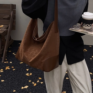 Macro detail of large leopard print tote bag with premium faux suede texture and leather strap