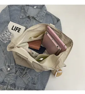 Vue intérieure du sac cabas beige montrant sa grande capacité et ses nombreux compartiments