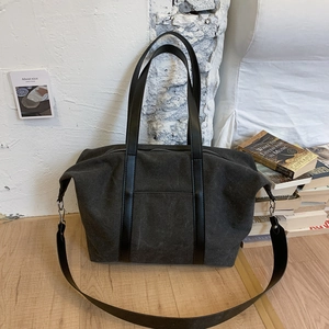 Détail du grand sac cabas gris foncé avec poignées en cuir sur parquet clair