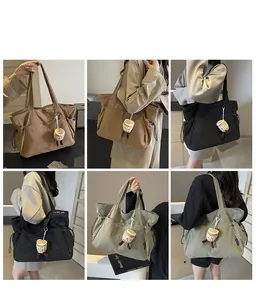 Détail du grand sac cabas en marron foncé, noir et vert avec de jolis charms de sac
