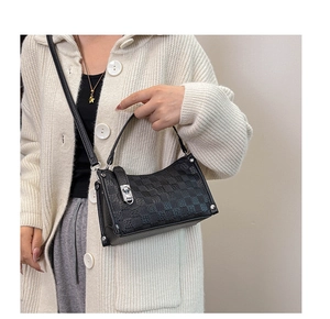Detail of black checkered shoulder bag featuring silver twist lock and rivet accents