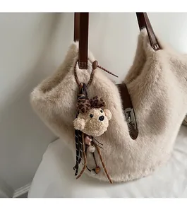 Détail du sac fourre-tout en peluche crème avec bandoulière cuir et charme d'ours