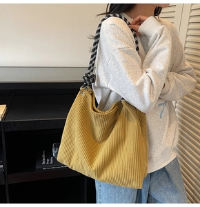 Detail of yellow corduroy tote bag featuring checkered braided rope strap and soft texture