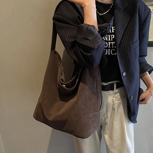 Side view of oversized dark brown hobo tote bag on model showing soft silhouette and texture