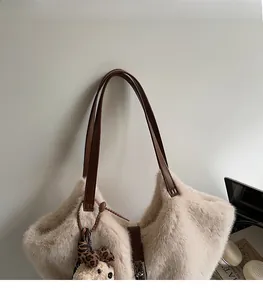 Détail du cabas en peluche crème avec bandoulières en cuir marron et breloque ours