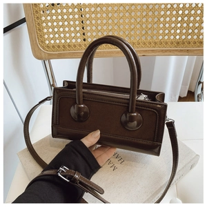Detailed macro view of dark brown vintage style box bag with dual top handles and zipper