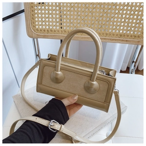 Detail of beige contrast handbag showing textured leather finish and adjustable strap