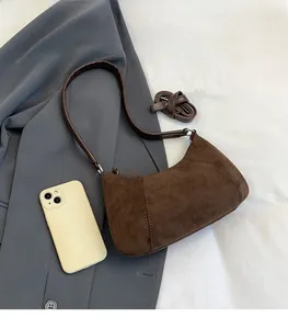 Detailansicht der kaffeebraunen Wildledertasche mit Ziernähten und schlankem Riemen