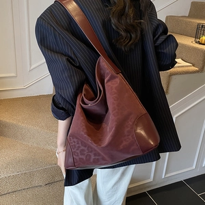 Detail of burgundy leopard jacquard hobo bag with leather trim and wide shoulder strap