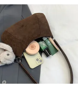 Macro shot of large capacity dark brown suede bag with plush bunny keychain and essentials