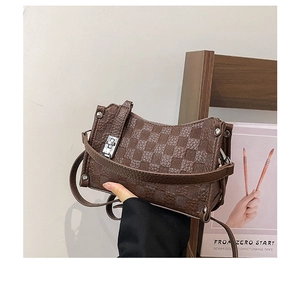 Detailed view of dark brown checkered pillow bag with silver twist lock and leather strap