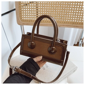 Detail view of the vintage brown handbag showing leather texture and silver hardware details