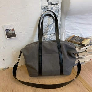 Détail du sac cabas en toile gris foncé avec poignées en cuir et bandoulière amovible