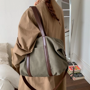Détail du sac fourre-tout en toile olive avec lanières en cuir brun et grand espace