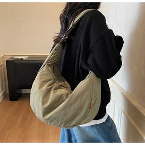 Minimalist military green crossbody bag featuring spacious design and nylon texture