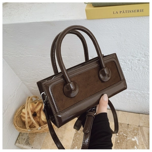 Detailed look at dark brown leather tote bag with vintage stitching and silver hardware