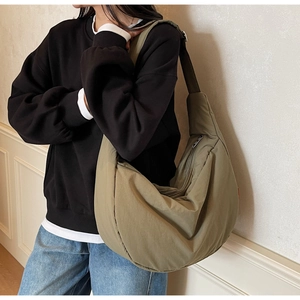 Close-up of olive green large capacity crescent moon nylon crossbody bag on model