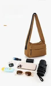 Detail view of large capacity nylon crossbody bag showing organized daily essentials