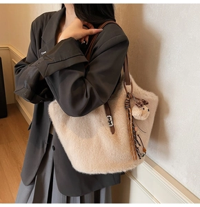 Détail du sac seau en fausse fourrure avec bandoulière en cuir et breloque ours