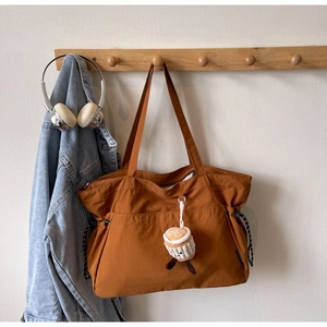 Détail d'un grand sac fourre-tout marron caramel avec poches et cordon de serrage