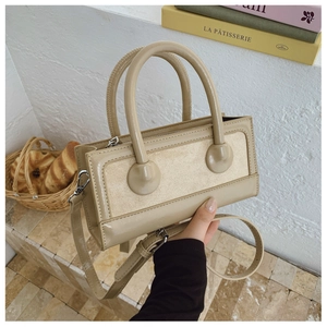 Close-up of beige vintage crossbody bag with dual textures and golden zippers