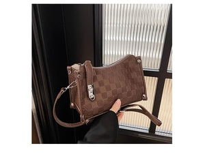 Detail view of brown checkerboard pattern bag with silver hardware and padlock closure