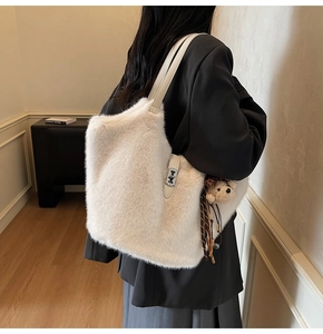 Détails de texture du sac fourre-tout en fausse fourrure blanche avec breloque ours