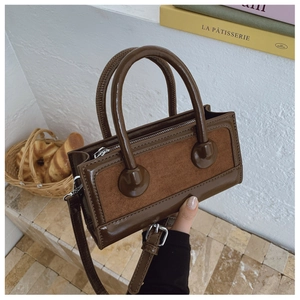 Detail of dark brown handbag showing shiny faux leather and suede texture contrast
