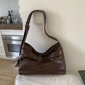 Detail view of deep brown vintage crescent bag with adjustable buckle and silver metal eyelets